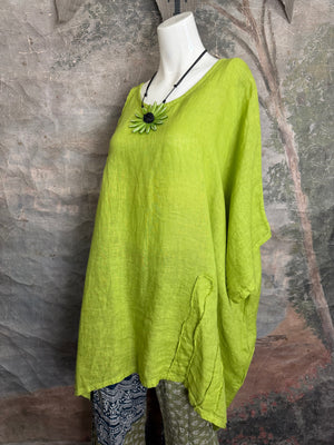 Oversized lime green linen tunic top with asymmetric hem and flower pendant necklace on white mannequin - 9