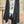Load image into Gallery viewer, Long black sleeveless open front duster vest styled with graphic tee, gingham pants, and black beaded necklace on hanger - 5
