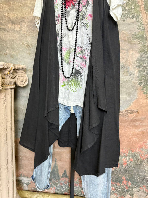 Long black sleeveless open front duster vest styled with graphic tee, gingham pants, and black beaded necklace on hanger - 5