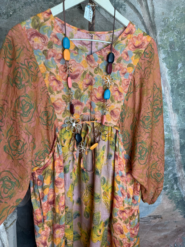 Woman wearing DYM90081 Bloomspell Maxi Dress in orange floral print with pink Converse sneakers in boutique setting - 7