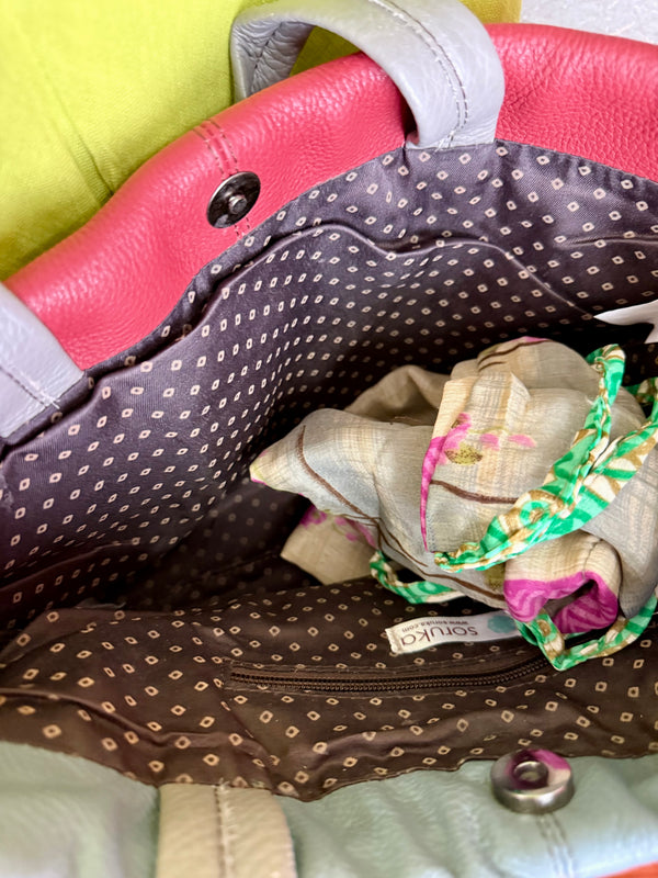 Alma shoulder bag in red pebbled leather with gray handles and teal accents on lime green dress mannequin - 5