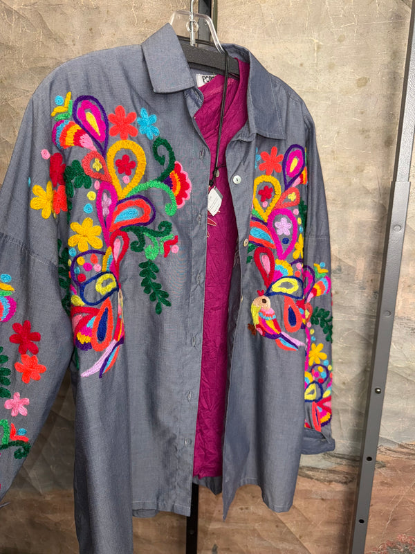 Fiesta denim boyfriend shirt with vibrant multicolor floral embroidery on chambray blue, displayed on hanger with pink l - 10