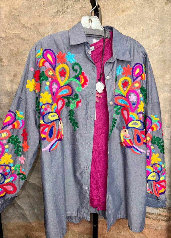 Fiesta denim boyfriend shirt with vibrant multicolor floral embroidery on chambray blue, displayed on hanger with pink l - 1