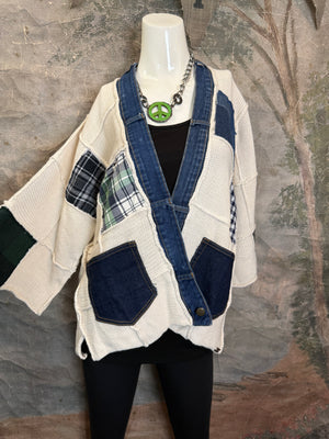 Cream knit cardigan with denim patchwork accents, plaid fabric inserts, and front pockets on mannequin with peace sign n - 4