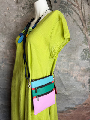 Colorblock crossbody bag in teal, green, and pink with zip pockets on lime green dress mannequin - 2