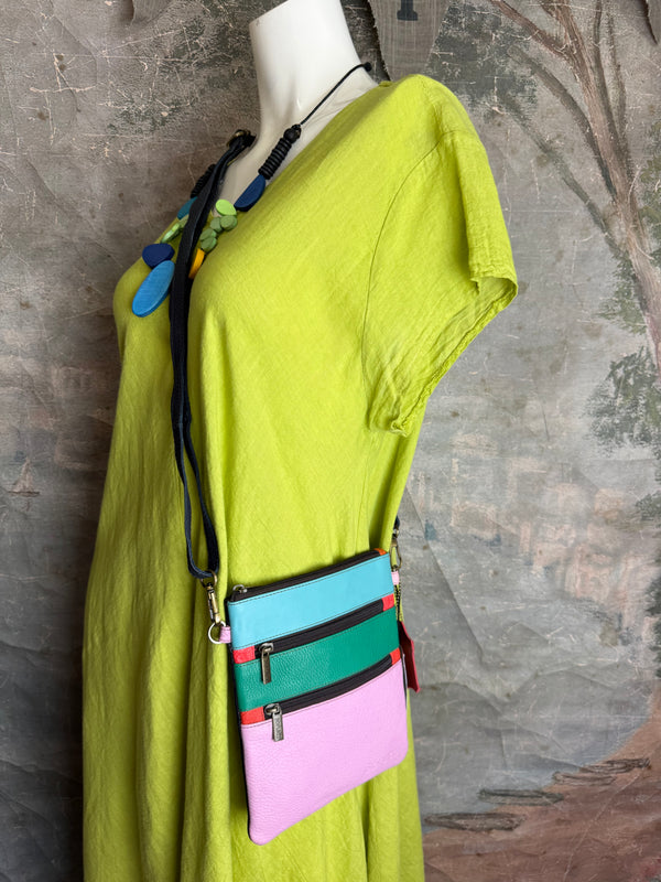 Colorblock crossbody bag in teal, green, and pink with zip pockets on lime green dress mannequin - 2