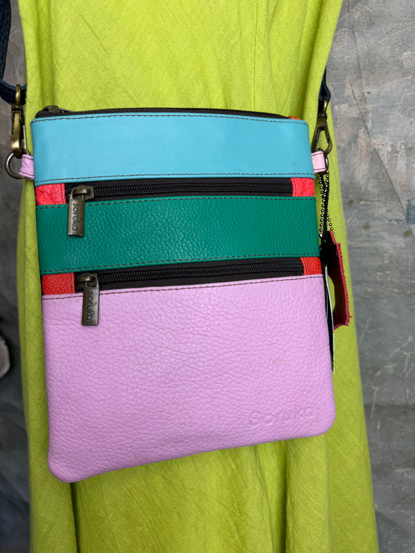 Colorblock crossbody bag in teal, green, and pink with zip pockets on lime green dress mannequin - 6