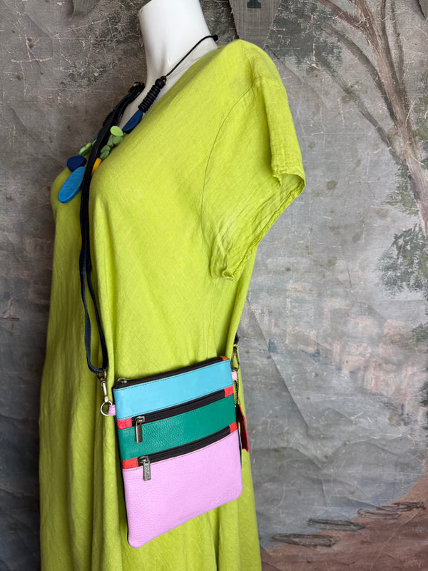 Colorblock crossbody bag in teal, green, and pink with zip pockets on lime green dress mannequin - 9