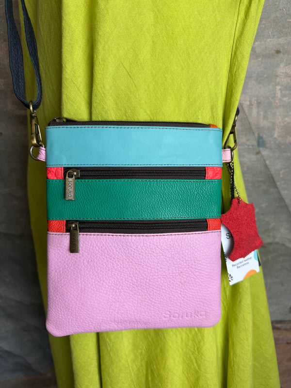 Colorblock crossbody bag in teal, green, and pink with zip pockets on lime green dress mannequin - 10