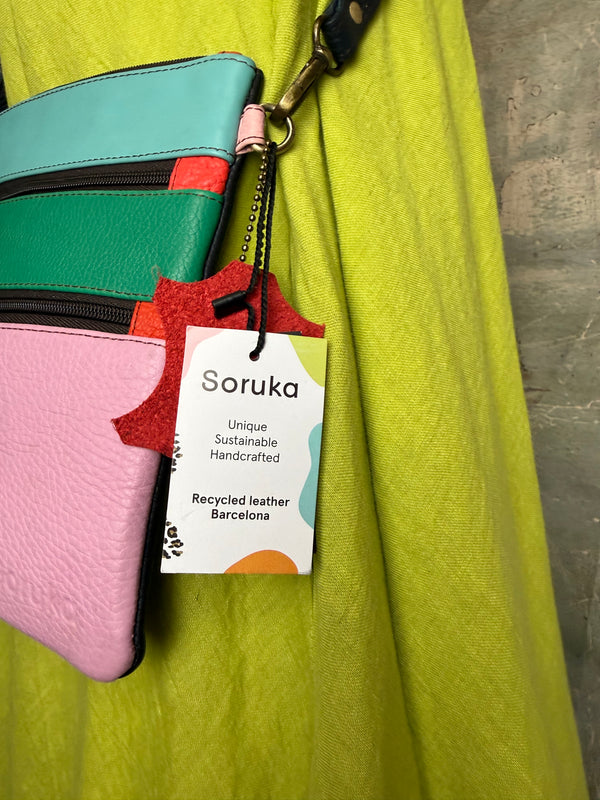 Colorblock crossbody bag in teal, green, and pink with zip pockets on lime green dress mannequin - 12