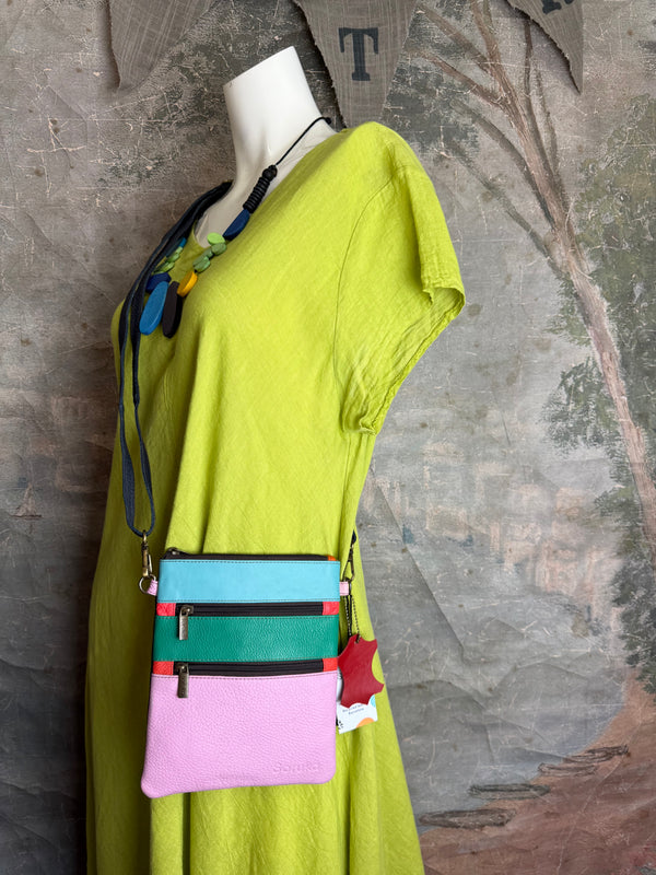 Colorblock crossbody bag in teal, green, and pink with zip pockets on lime green dress mannequin - 16