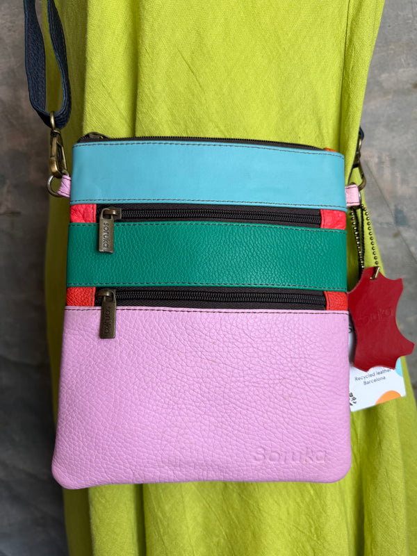 Colorblock crossbody bag in teal, green, and pink with zip pockets on lime green dress mannequin - 17