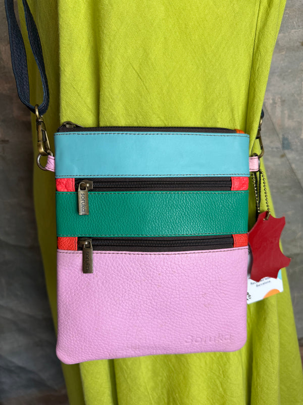 Colorblock crossbody bag in teal, green, and pink with zip pockets on lime green dress mannequin - 18