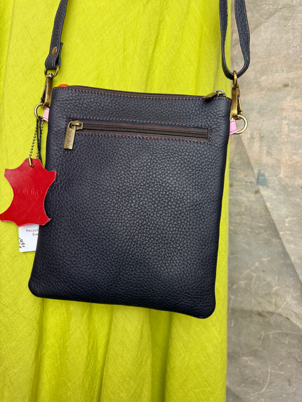 Colorblock crossbody bag in teal, green, and pink with zip pockets on lime green dress mannequin - 20