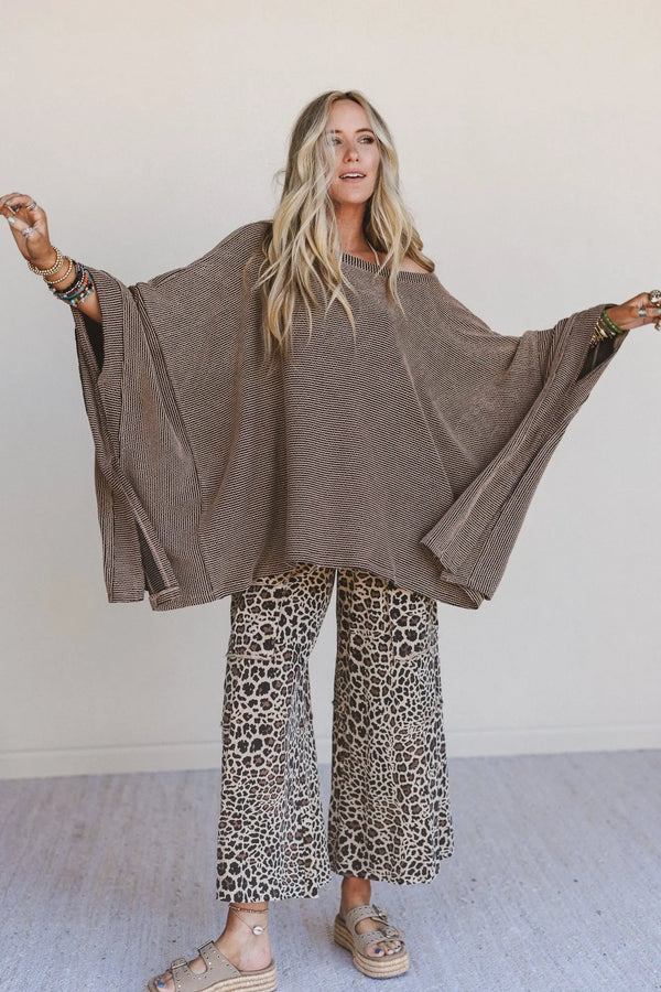 Woman wearing oversized brown ribbed knit tunic top with wide sleeves paired with leopard print wide-leg pants - 1