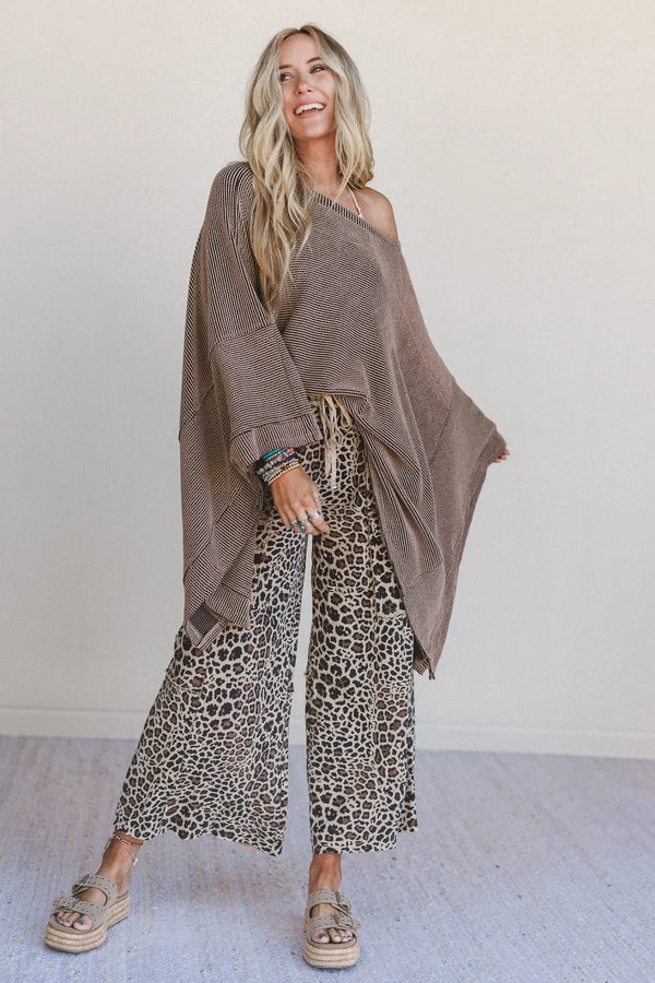 Woman wearing oversized brown ribbed knit tunic top with wide sleeves paired with leopard print wide-leg pants - 4