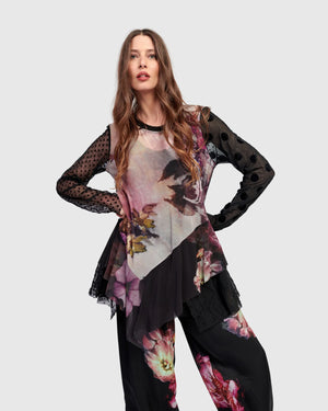 Woman wearing ET136M Fabulous Tunic Top with dark floral print, sheer black lace sleeves, and layered hem - 2