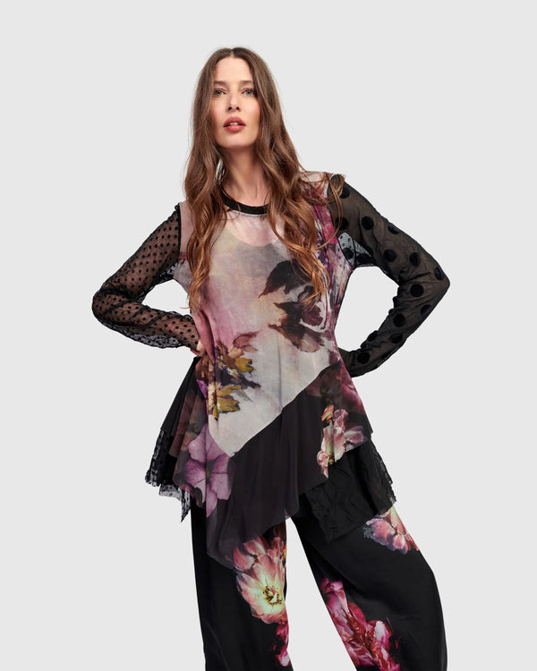 Woman wearing ET136M Fabulous Tunic Top with dark floral print, sheer black lace sleeves, and layered hem - 2