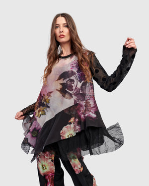 Woman wearing ET136M Fabulous Tunic Top with dark floral print, sheer black lace sleeves, and layered hem - 1
