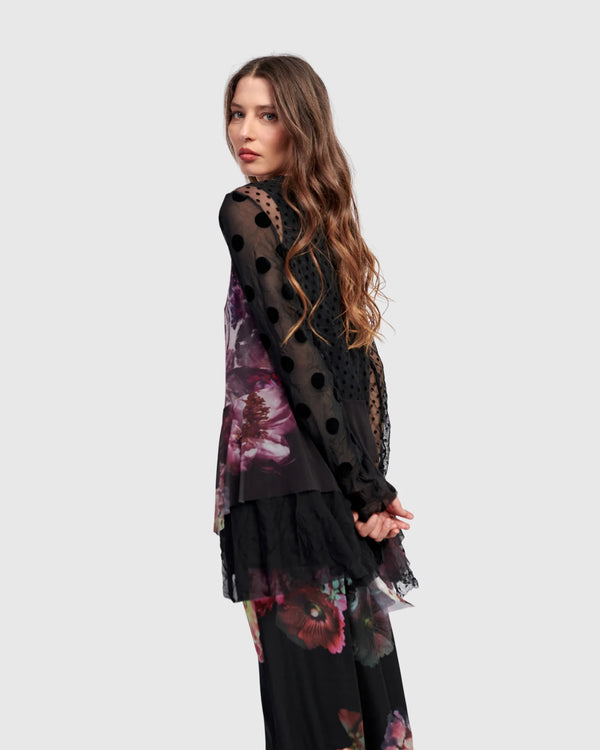 Woman wearing ET136M Fabulous Tunic Top with dark floral print, sheer black lace sleeves, and layered hem - 5