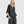 Load image into Gallery viewer, Woman wearing black taffeta butterfly top with flared sleeves and gathered waist paired with dark cargo pants - 1
