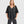 Load image into Gallery viewer, Woman wearing black taffeta butterfly top with flared sleeves and gathered waist paired with dark cargo pants - 2
