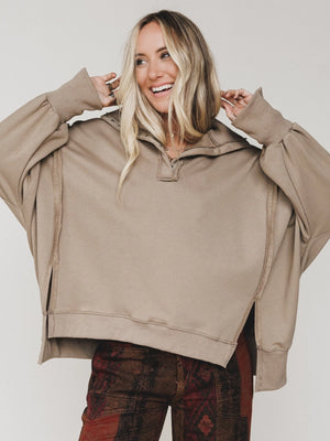 Woman wearing oversized taupe quarter-zip pullover sweatshirt with exposed seams and ribbed cuffs - 2