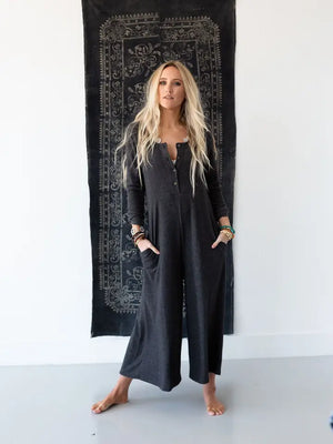 Woman wearing TBN3980 Comfort Jumpsuit in charcoal gray, long sleeve wide leg style with button front detail - 1