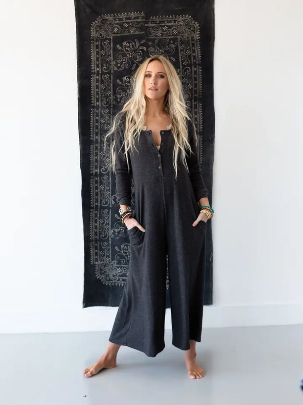 Woman wearing TBN3980 Comfort Jumpsuit in charcoal gray, long sleeve wide leg style with button front detail - 1