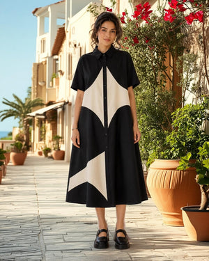 Woman wearing black and cream colorblock button-down midi shirt dress with geometric pattern and short sleeves - 1